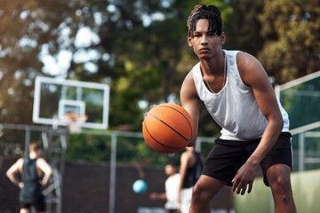 Lets bounce. Portrait of a sporty young man standing on a basketball court. - Powered by Adobe