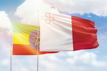 Sunny blue sky and flags of malta and ethiopia