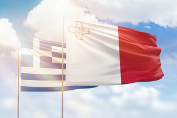 Sunny blue sky and flags of malta and greece
