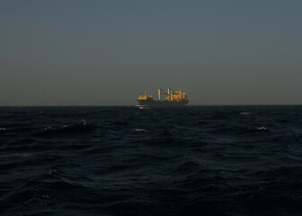 A merchant ship underway at sea in rough weather