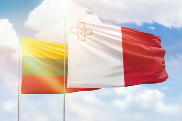 Sunny blue sky and flags of malta and lithuania