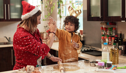 We make a great team. Cropped shot of a cheerful young woman and her son baking cookies together in the kitchen during christmas time at home.