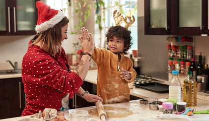 We make a great team. Cropped shot of a cheerful young woman and her son baking cookies together in...