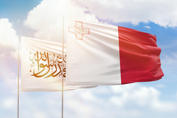 Sunny blue sky and flags of malta and afghanistan