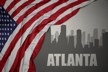 abstract silhouette of the city with text atlanta near waving national flag of united states of america on a gray background. - obrazy, fototapety, plakaty