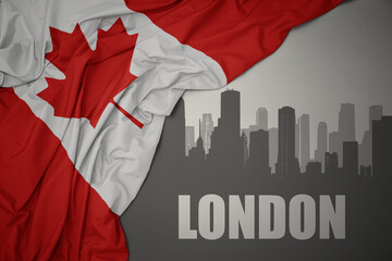 abstract silhouette of the city with text London near waving national flag of canada on a gray background.