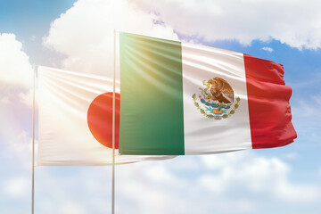 Sunny blue sky and flags of mexico and japan
