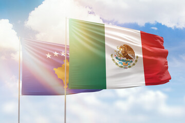 Sunny blue sky and flags of mexico and kosovo