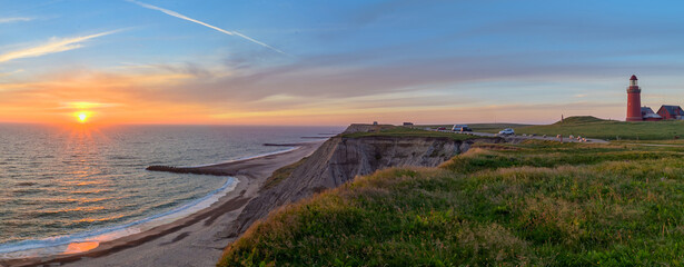 Panoramic view of the cliffs at the danish coast with the red lighthouse Bovbjerg Fyr. Panoramic view of beautiful nature landscape  at the Danish North Sea coast, Jutland, Denmark, Europe. - obrazy, fototapety, plakaty