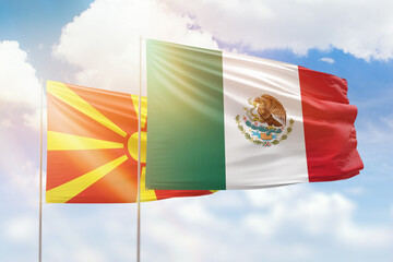 Sunny blue sky and flags of mexico and north macedonia