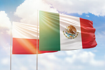 Sunny blue sky and flags of mexico and poland