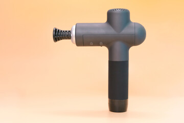 Front view of massage percussion device on yellow background. Stress. Therapy. Training. Treatment. Wellness. Workout. Device. Gun. Hammer. Health. Rehab. Sport