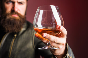 Male hand with glass of whiskey or brandy. Alcoholic drink. Degustation, tasting. Party, holiday.