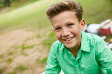 Hes going to break some hearts one day. Portrait of a smiling boy sitting outside.