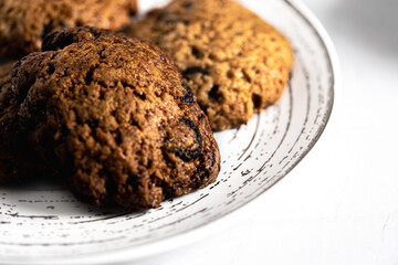 macro, close-up photo of handmade cookies on modern designer plate with chocolate chips. copy space