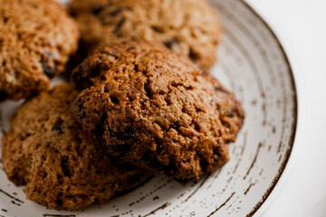 macro, close-up photo of handmade cookies on modern designer plate with chocolate chips. copy space