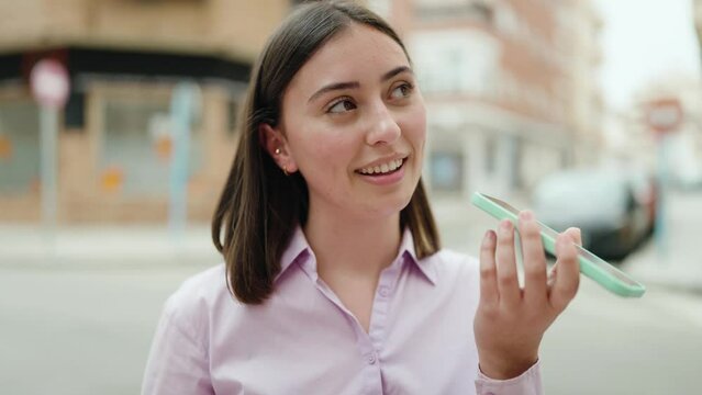 Young hispanic woman smiling confident talking on the smartphone at street