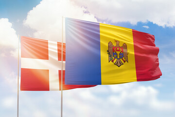 Sunny blue sky and flags of moldova and denmark