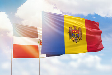 Sunny blue sky and flags of moldova and dominican republic