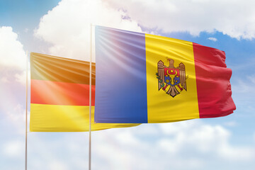 Sunny blue sky and flags of moldova and germany