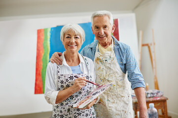 Love is the spirit that motivates the artists journey. Shot of a senior couple painting at home.