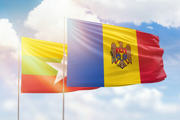 Sunny blue sky and flags of moldova and myanmar