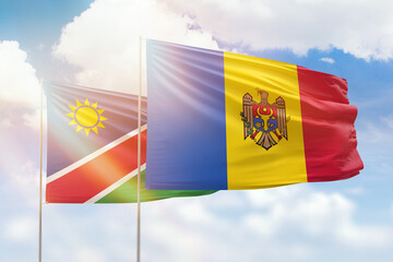 Sunny blue sky and flags of moldova and namibia