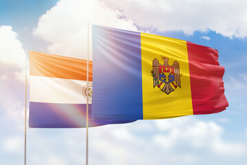 Sunny blue sky and flags of moldova and paraguay