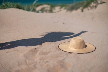 Fototapeta na wymiar Shadow of girl on beach with hat