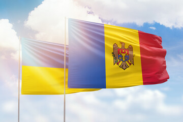 Sunny blue sky and flags of moldova and ukraine
