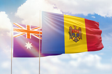 Sunny blue sky and flags of moldova and australia