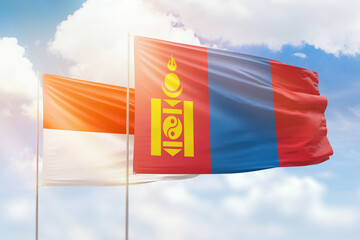 Sunny blue sky and flags of mongolia and indonesia