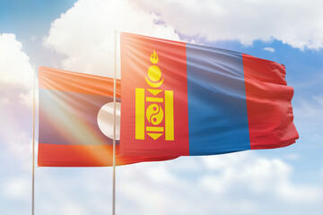 Sunny blue sky and flags of mongolia and laos