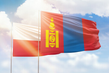 Sunny blue sky and flags of mongolia and poland