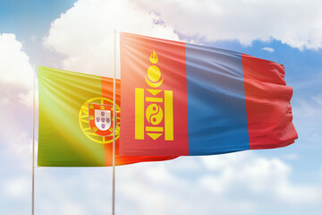 Sunny blue sky and flags of mongolia and portugal