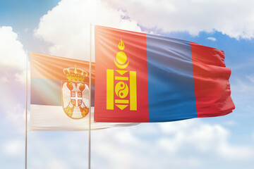 Sunny blue sky and flags of mongolia and serbia
