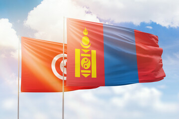Sunny blue sky and flags of mongolia and tunisia