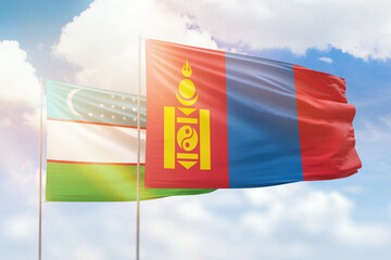 Sunny blue sky and flags of mongolia and uzbekistan