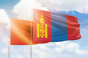 Sunny blue sky and flags of mongolia and albania
