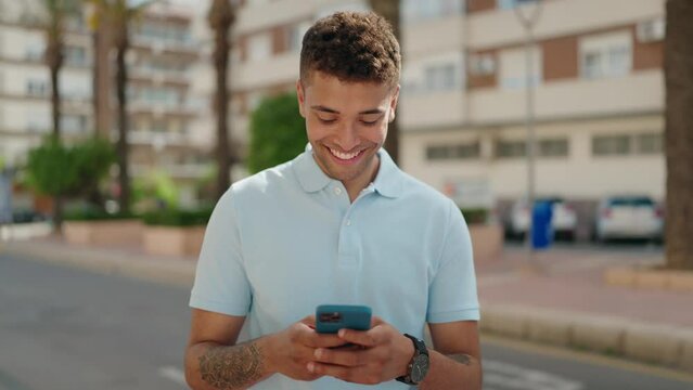 African american man smiling confident using smartphone at street