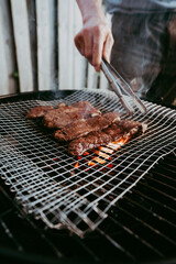 Man grilling smoky meat out in backyard barbeque