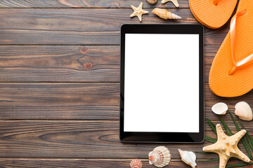 Flat lay composition with tablet and beach accessories on colored background. Tablet computer with blank screen mock up with copy space