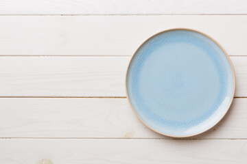 Fototapeta na wymiar Top view of empty blue plate on wooden background. Empty space for your design