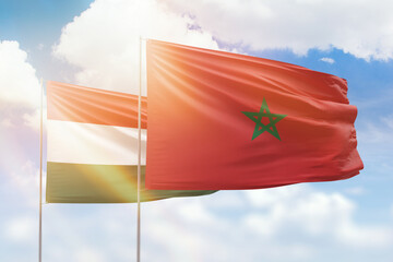 Sunny blue sky and flags of morocco and hungary