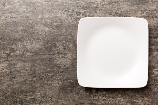 Top view of empty square plate on cement background. Empty space for your design