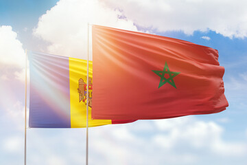 Sunny blue sky and flags of morocco and moldova
