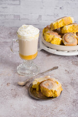 pumpkin cinnabons and latte for dessert, holiday table with pastries, home sweet