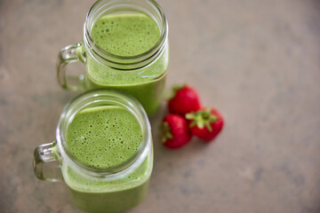 green smoothie on kitchen counter with strawberries