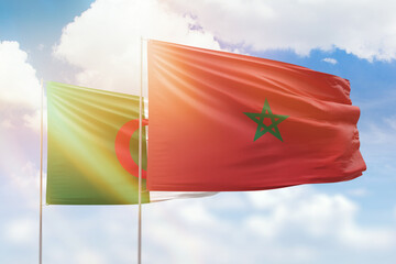 Sunny blue sky and flags of morocco and algeria
