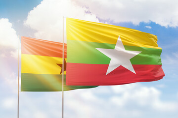 Sunny blue sky and flags of myanmar and ghana